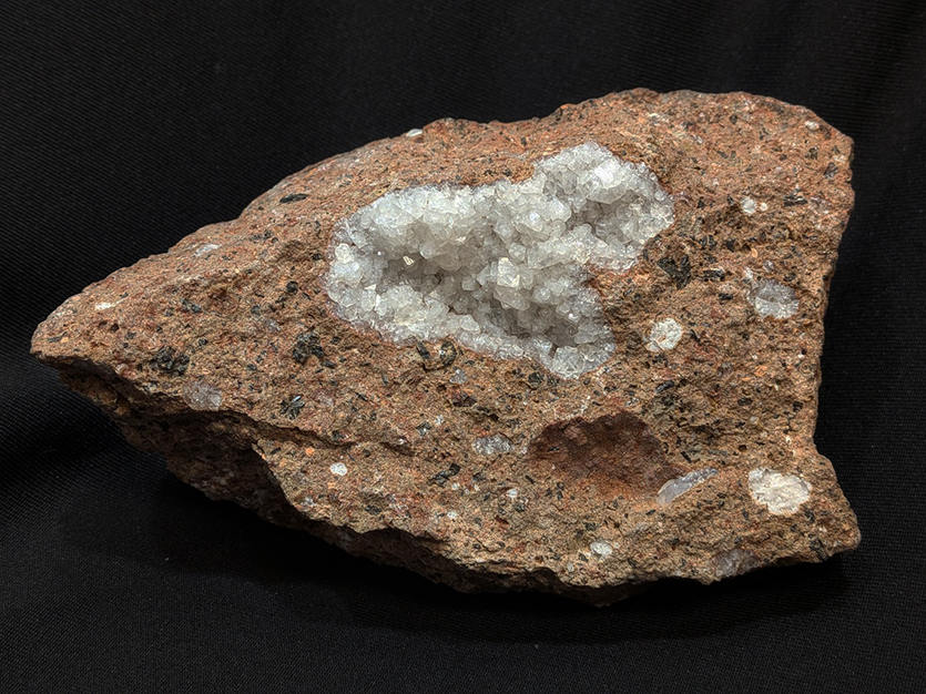 The white crystals that decorate the surface of the rock are an example of a naturally occurring zeolite found in Colorado. 