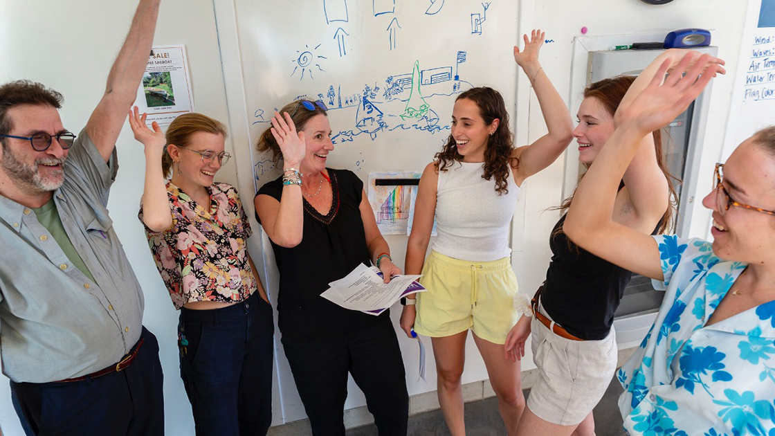 Lively photo of people collaborating in front of white board
